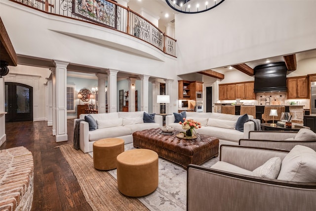 45 Dunrobin, Richardson, TX 75082 - living area featuring dark wood finished floors, ornate columns, a chandelier, and a high ceiling