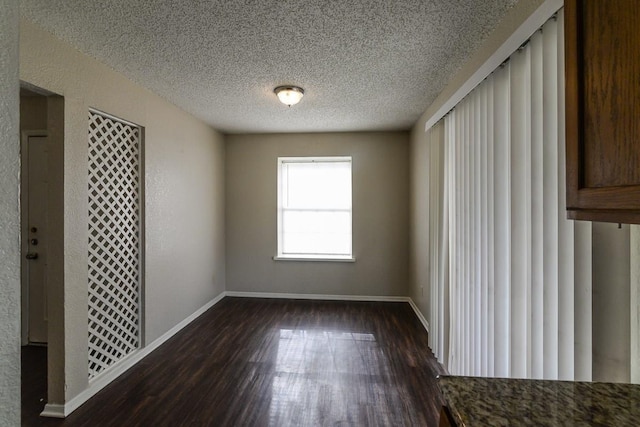 spare room with dark hardwood / wood-style flooring and a textured ceiling