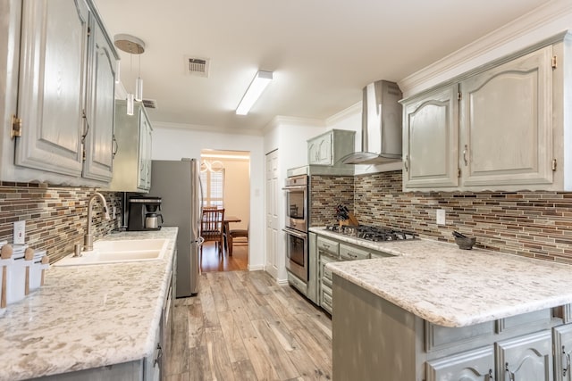 kitchen with wall chimney exhaust hood, sink, crown molding, kitchen peninsula, and stainless steel appliances