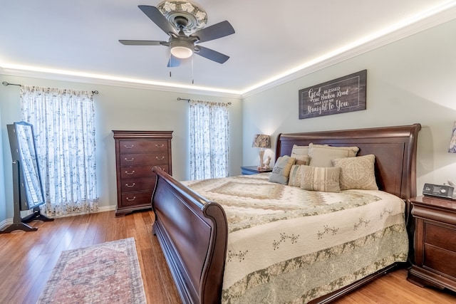 bedroom with ceiling fan, ornamental molding, and light hardwood / wood-style flooring