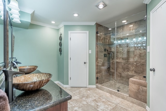 bathroom featuring ornamental molding, sink, and an enclosed shower