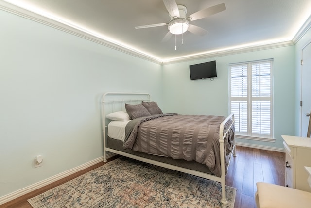 bedroom with crown molding, hardwood / wood-style floors, and ceiling fan