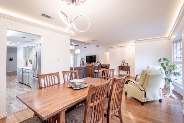 dining area with ornamental molding, ceiling fan, and light wood-type flooring