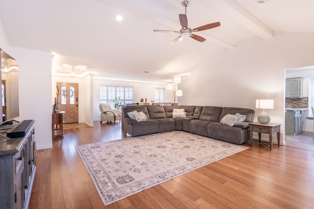 living room with ceiling fan, wood-type flooring, and lofted ceiling with beams