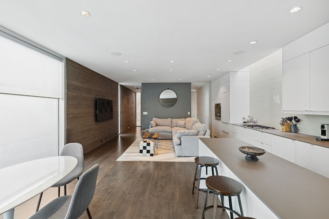 living room featuring dark hardwood / wood-style flooring and wooden walls