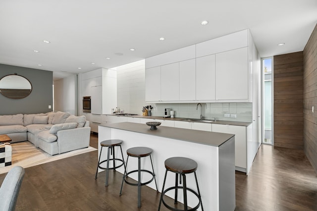 kitchen with stainless steel appliances, a kitchen island, sink, and white cabinets