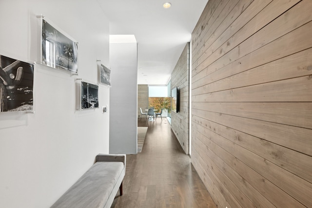 hall featuring hardwood / wood-style flooring and wooden walls