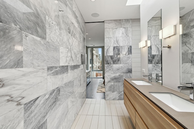 bathroom with tile patterned flooring, vanity, and tile walls