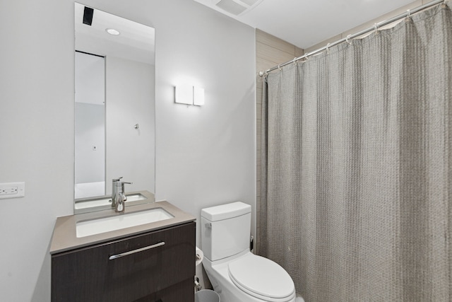 bathroom with walk in shower, vanity, and toilet