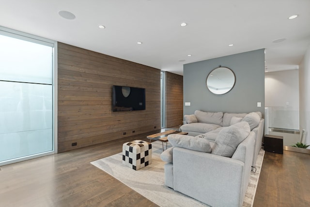 living room with wood walls, expansive windows, and light wood-type flooring