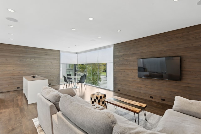 living room with hardwood / wood-style flooring, wooden walls, and floor to ceiling windows