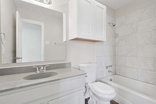 full bathroom featuring vanity, tiled shower / bath combo, toilet, and a textured ceiling