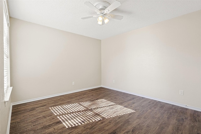 empty room with ceiling fan, dark wood-type flooring, and a textured ceiling