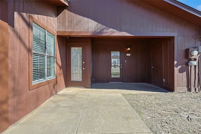 view of exterior entry with a patio