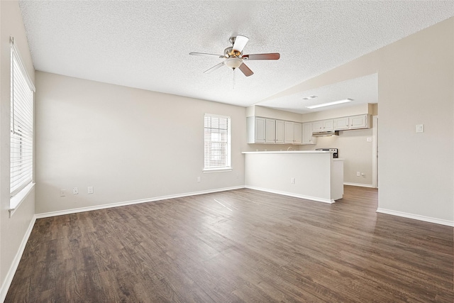 unfurnished living room featuring ceiling fan, dark hardwood / wood-style floors, and a textured ceiling