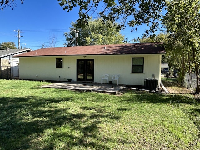 rear view of house featuring french doors, central AC unit, and a lawn