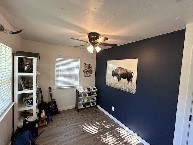 misc room with dark wood-type flooring and ceiling fan