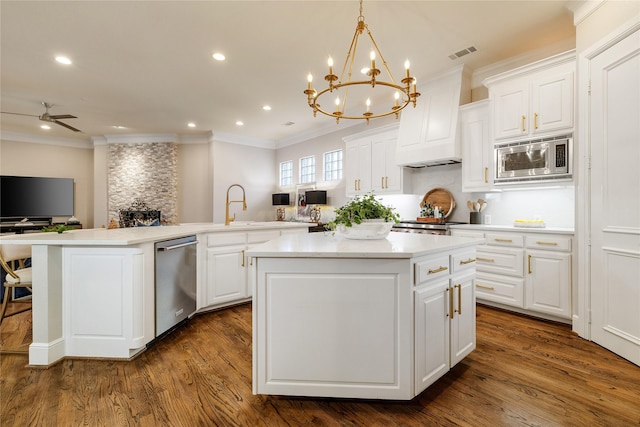 kitchen featuring a kitchen island, dark hardwood / wood-style floors, appliances with stainless steel finishes, decorative light fixtures, and white cabinets