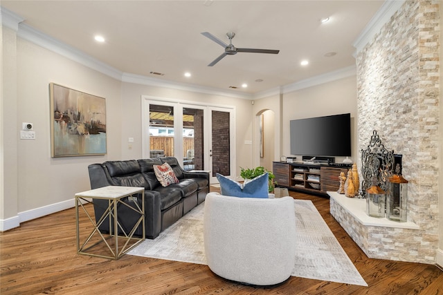 living room with hardwood / wood-style flooring, ornamental molding, and ceiling fan