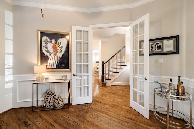 hall with wood-type flooring, crown molding, and french doors