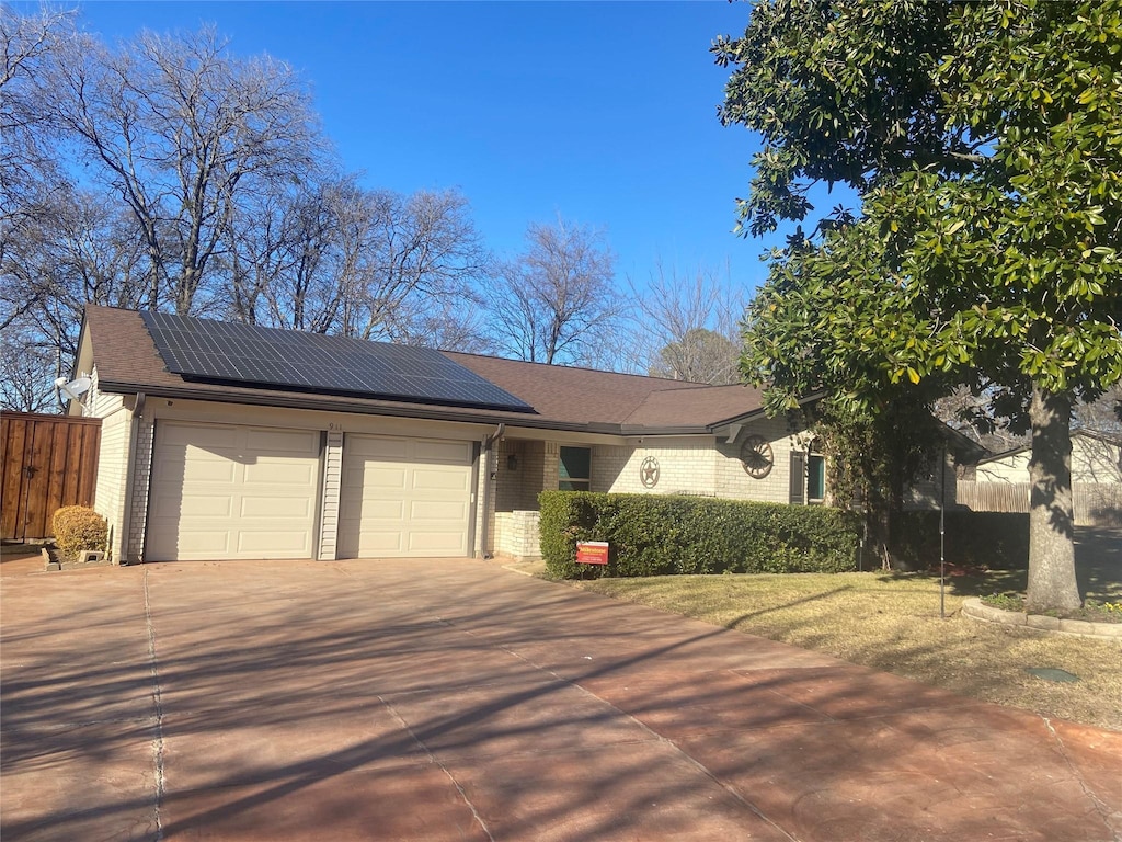 view of front of property with a garage and solar panels