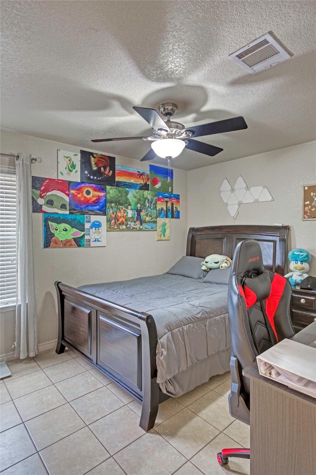 bedroom featuring ceiling fan, a textured ceiling, and light tile patterned floors