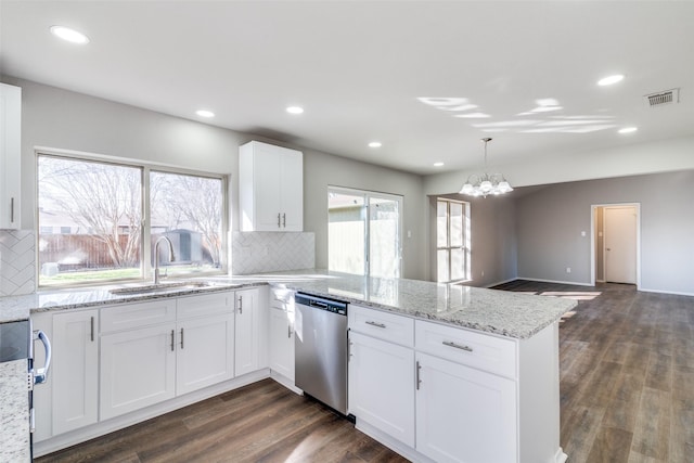 kitchen with sink, white cabinets, hanging light fixtures, stainless steel dishwasher, and kitchen peninsula