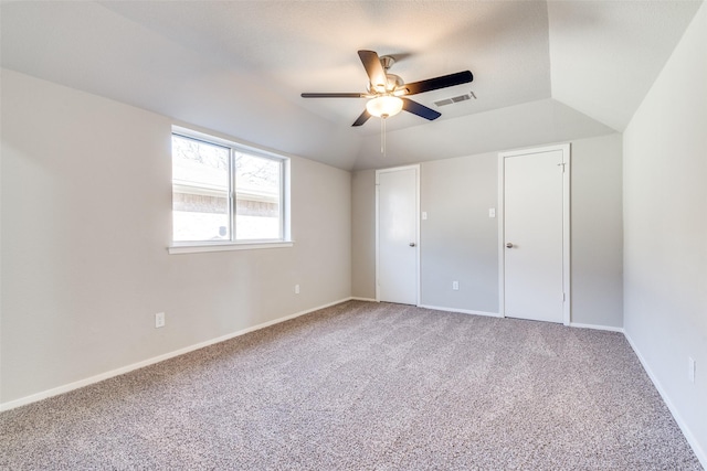 unfurnished bedroom featuring ceiling fan, carpet flooring, and vaulted ceiling