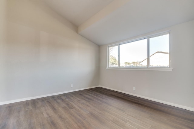 empty room with dark hardwood / wood-style flooring and lofted ceiling