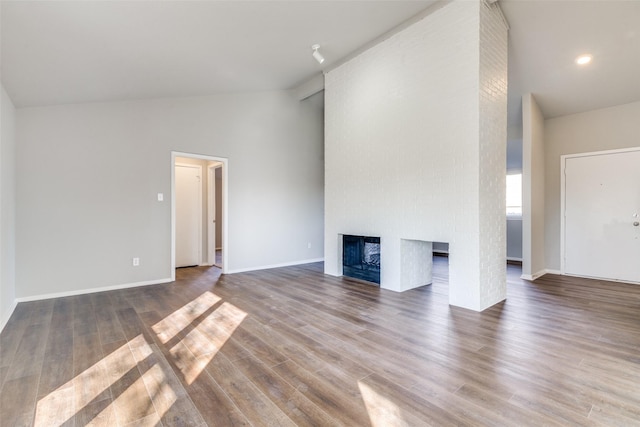 unfurnished living room with high vaulted ceiling, hardwood / wood-style floors, and a fireplace