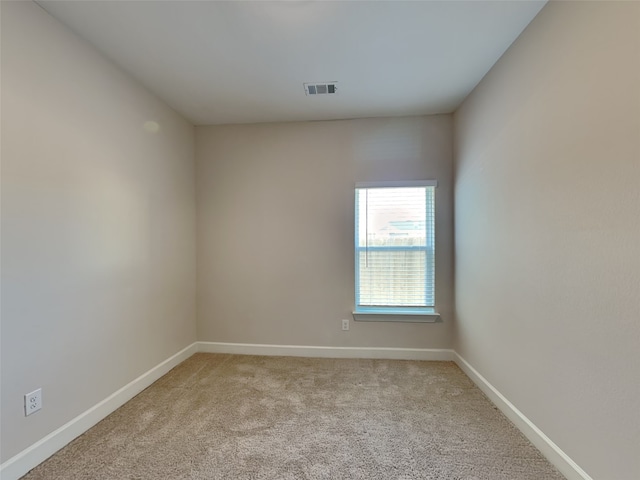 spare room featuring light colored carpet