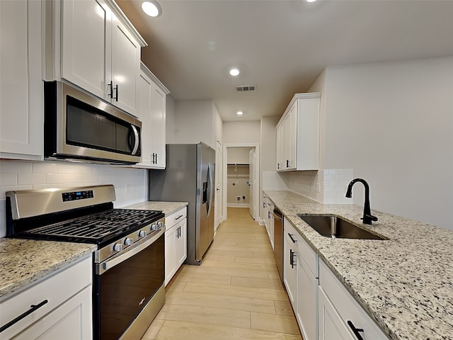 kitchen featuring stainless steel appliances, sink, and white cabinets