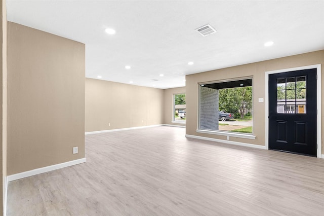 unfurnished living room featuring a wealth of natural light and light hardwood / wood-style flooring