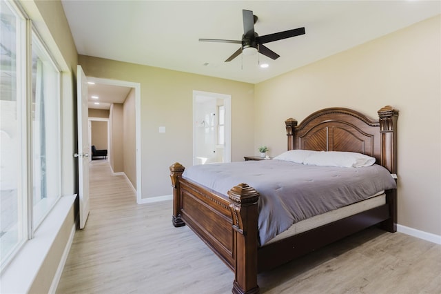 bedroom featuring ceiling fan, ensuite bathroom, and light hardwood / wood-style floors