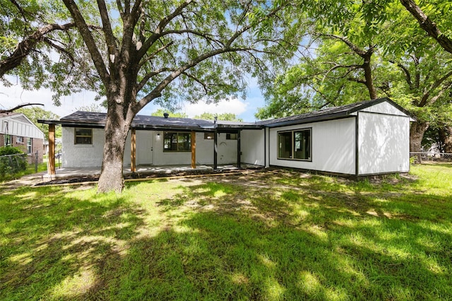 rear view of house featuring a patio area and a lawn