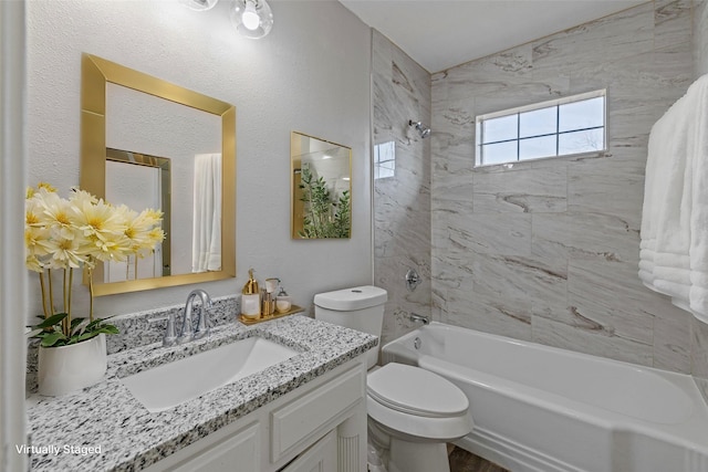 full bathroom with tiled shower / bath, vanity, and toilet