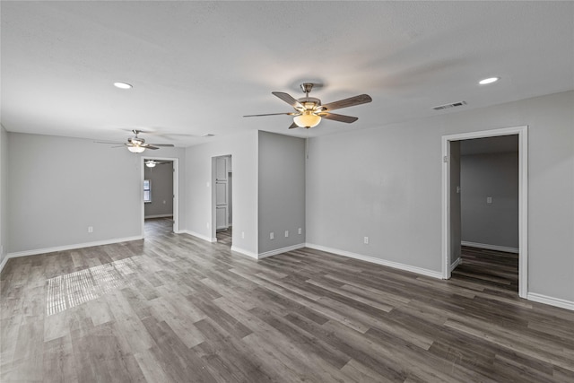 unfurnished living room featuring a textured ceiling, dark hardwood / wood-style floors, and ceiling fan