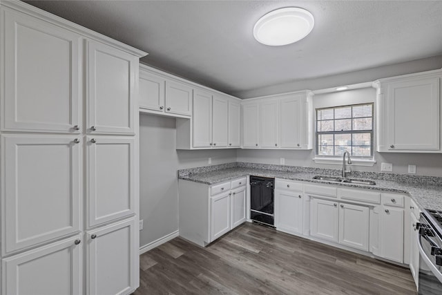 kitchen with sink, stove, black dishwasher, light stone countertops, and white cabinets