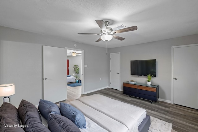 bedroom with hardwood / wood-style floors, a textured ceiling, and ceiling fan