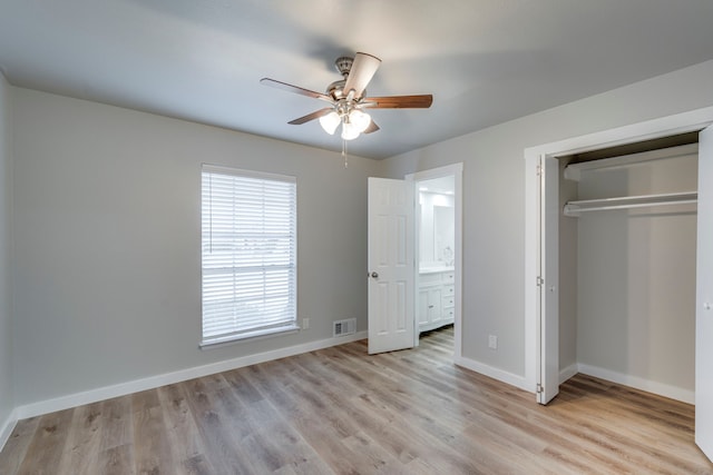 unfurnished bedroom featuring a closet, connected bathroom, ceiling fan, and light hardwood / wood-style flooring