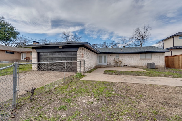 ranch-style home with a garage, a front lawn, a patio area, and central air condition unit