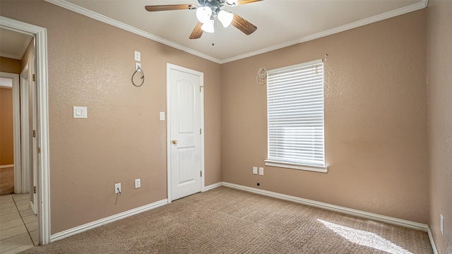 carpeted spare room with ornamental molding and ceiling fan