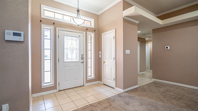 tiled foyer entrance with ornamental molding and a healthy amount of sunlight