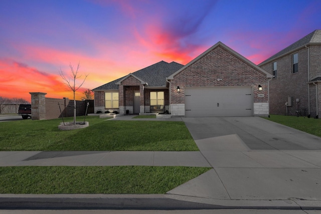 view of front of property with stone siding, concrete driveway, a front yard, a garage, and brick siding