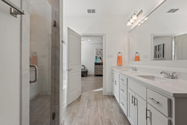 bathroom with a sink, visible vents, a stall shower, and double vanity