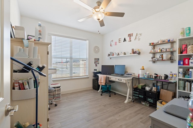 office area with light wood-style flooring, a ceiling fan, and baseboards