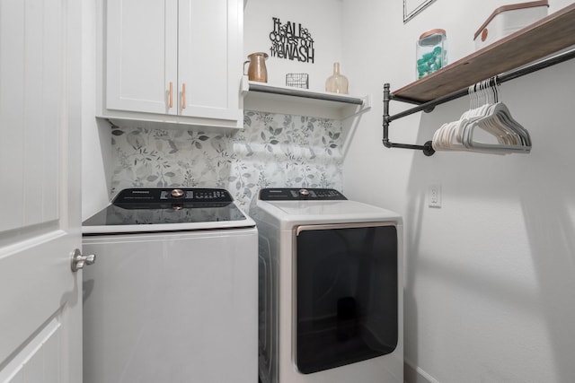 clothes washing area with washer and dryer and cabinets