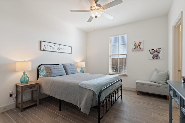 bedroom featuring a ceiling fan, baseboards, and wood tiled floor