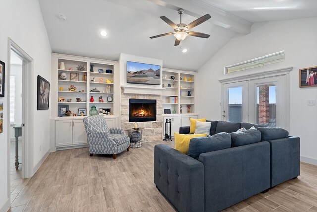 living area featuring vaulted ceiling with beams, baseboards, light wood-style flooring, a fireplace, and a ceiling fan