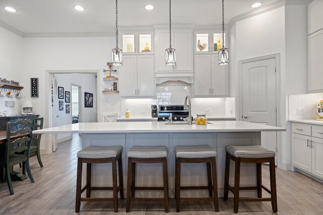 living room featuring ceiling fan, ornamental molding, sink, and light wood-type flooring